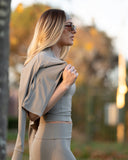 Woman in a beige outfit with a blurred outdoor background