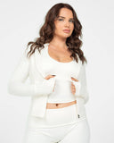 Woman wearing a white outfit against a plain background