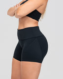 Person wearing black athletic shorts and top on a light gray background