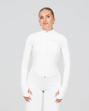 Woman wearing a white outfit against a plain background